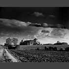 black and white photo of Grain silo near Gransden Lodge Airfield under stormy sky